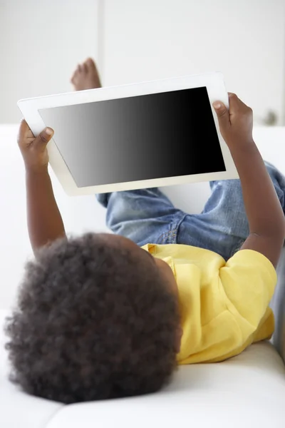 Niño feliz en el sofá jugando con la tableta digital —  Fotos de Stock