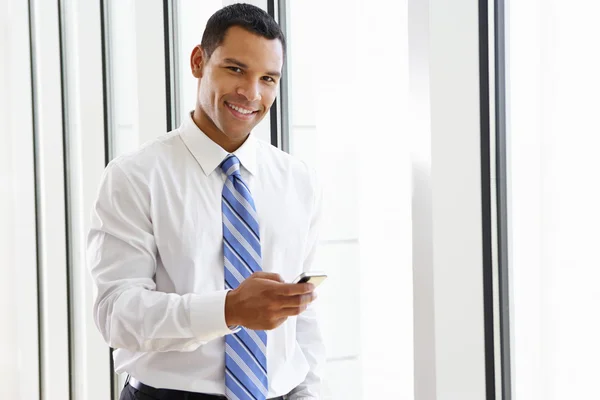 Affärsman som använder mobiltelefon på kontoret — Stockfoto