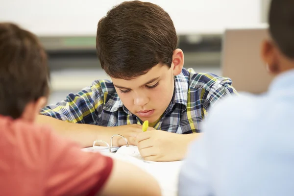 Leerlingen studeren aan bureaus in klas — Stockfoto