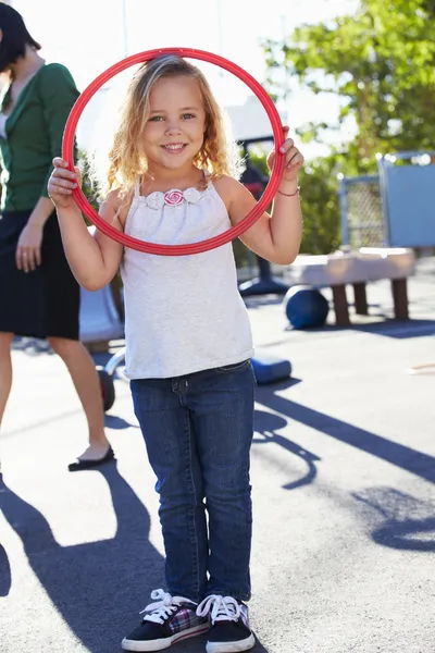 Menina no playground da escola com aro — Fotografia de Stock