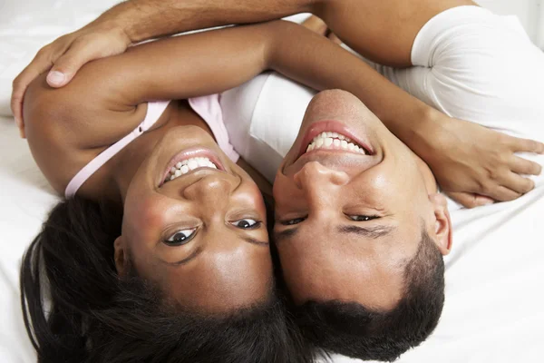 Casal relaxante na cama vestindo pijamas — Fotografia de Stock