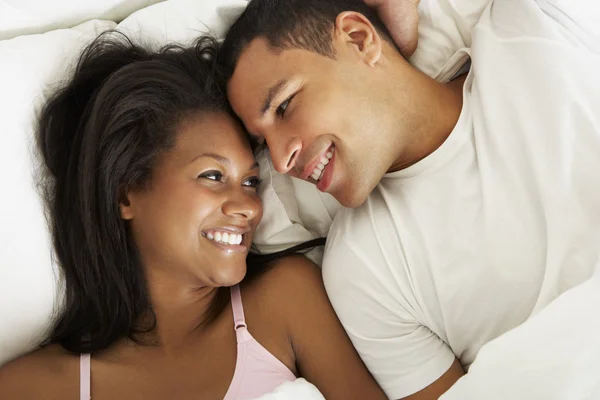 Casal relaxante na cama vestindo pijamas — Fotografia de Stock