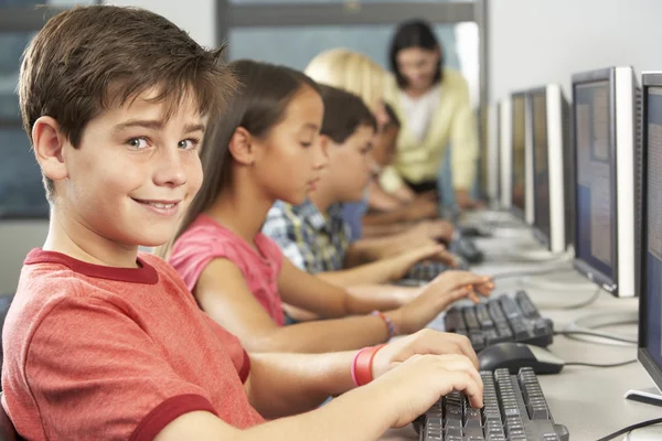 Elementaire studenten die werken op computers in klas — Stockfoto