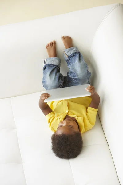 Visão aérea do menino no sofá que joga com tabuleta digital — Fotografia de Stock