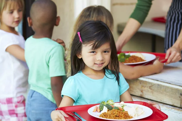 Alumnos elementales recogiendo un almuerzo saludable en la cafetería — Foto de Stock