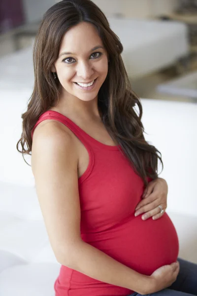 Femme enceinte assise sur le canapé — Photo