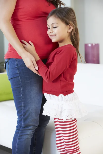 Dochter luisteren naar zwangere moeder maag — Stockfoto