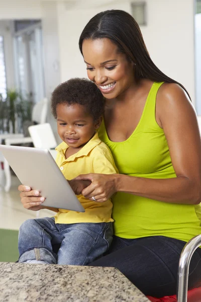 Mutter und Sohn nutzen gemeinsam digitales Tablet in der Küche — Stockfoto