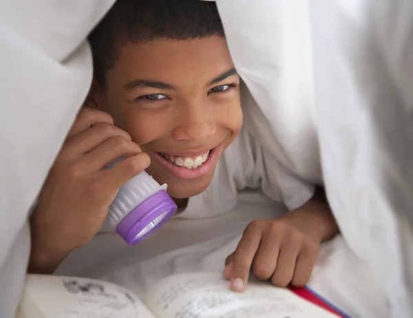 Boy Reading Book With Torch Under Duvet — Stock Photo, Image