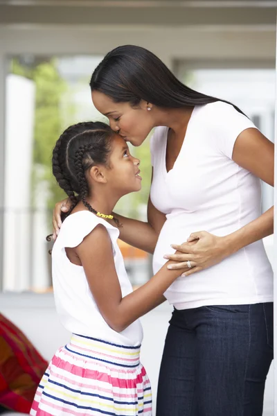 Hija abrazando embarazada madre — Foto de Stock