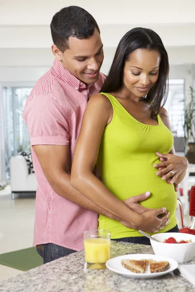 Gravid kvinna och man äter frukost i köket — Stockfoto