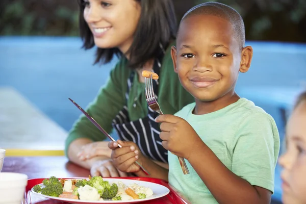 Podstawowej uczniów korzystających z zdrowy obiad w stołówce — Zdjęcie stockowe