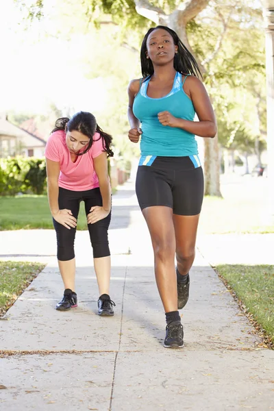 Två kvinnliga löpare utövar på suburban street — Stockfoto