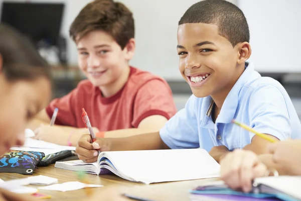 Pupils Studying At Desks In Classroom Stock Image