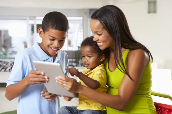 Mère et enfants utilisant la tablette numérique dans la cuisine ensemble Images De Stock Libres De Droits