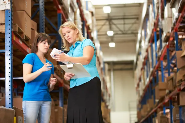 Femme d'affaires et ouvrière dans l'entrepôt de distribution — Photo