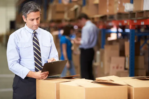 Administrador en cajas de verificación de almacén — Foto de Stock