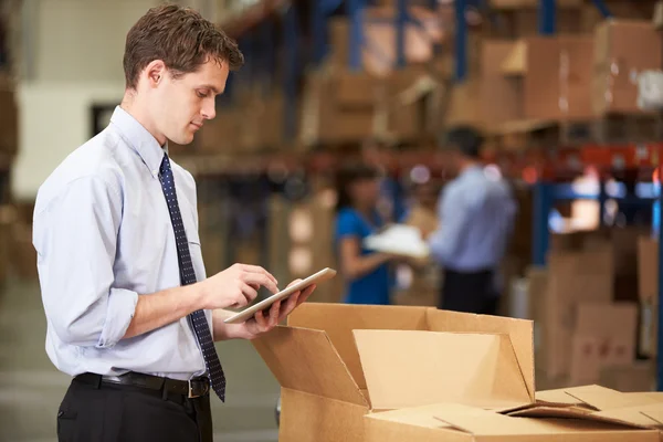 Administrador en cajas de verificación de almacén usando tableta digital — Foto de Stock