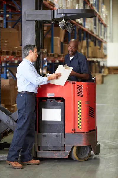 Fork Lift Truck Operator Talking To Manager In Warehouse — Stock Photo, Image