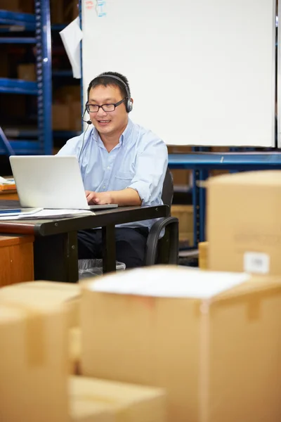Arbetare i lager bära headsetet och med laptop — Stockfoto