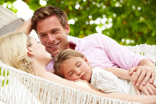 Familie ontspannen in strand hangmat met slapende dochter — Stockfoto