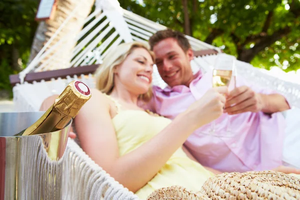 Casal relaxante na praia rede bebendo champanhe — Fotografia de Stock