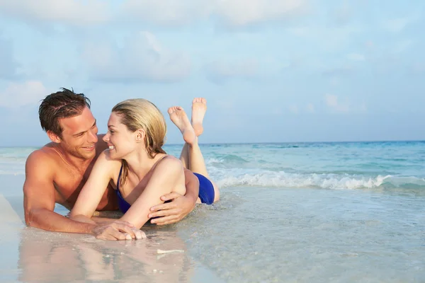 Coppia romantica sdraiata in mare sulla spiaggia tropicale vacanza — Foto Stock