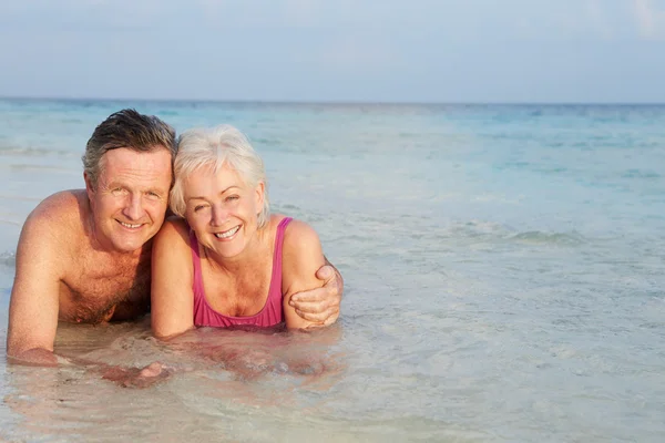 Couple sénior romantique allongé en mer sur la plage vacances — Photo