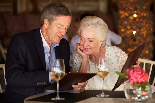 レストランのメニューから選択する年配のカップル — ストック写真