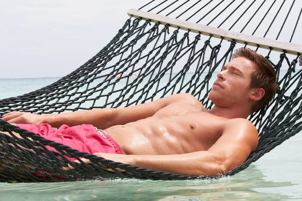 Homem relaxante na rede de praia — Fotografia de Stock