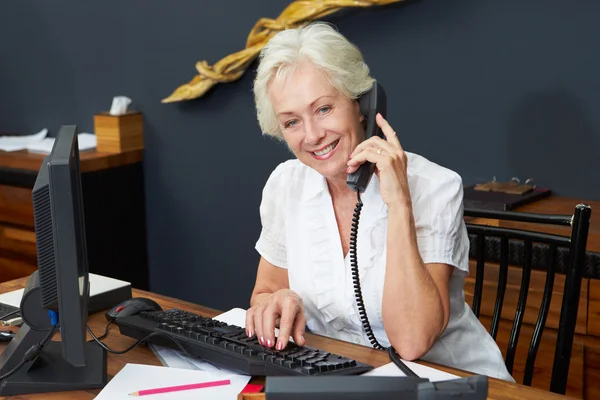 Recepcionista del hotel usando computadora y teléfono — Foto de Stock