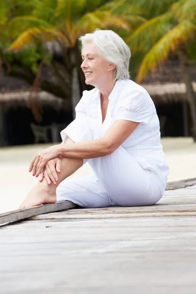 Seniorin sitzt auf Holzsteg — Stockfoto