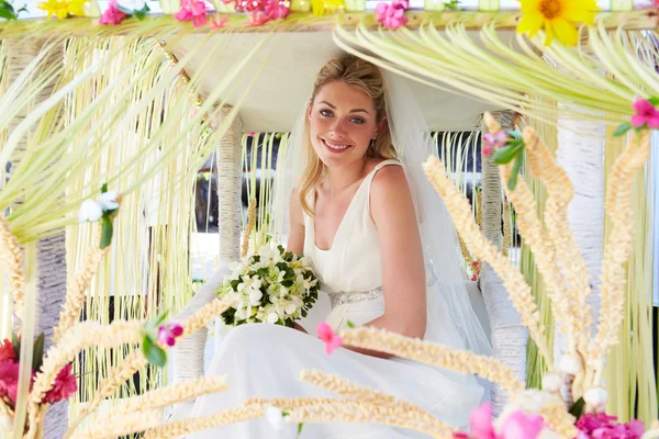 Brud sitter under dekorerat tak på bröllop — Stockfoto