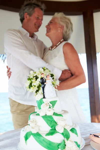 Cerimônia de casamento de praia sênior com bolo em primeiro plano — Fotografia de Stock