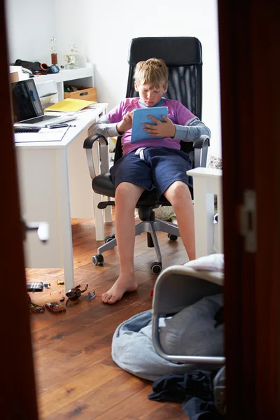 Мальчик с цифровым планшетом в спальне — стоковое фото