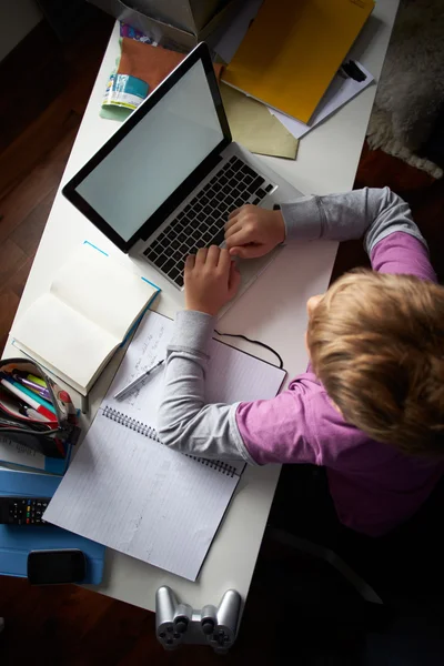 Bovenaanzicht van jongen studeren in slaapkamer met behulp van laptop — Stockfoto