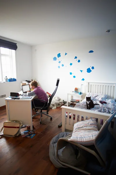 Jongen met behulp van laptop in slaapkamer — Stockfoto