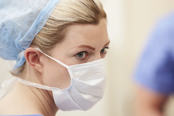 Enfermeira vestindo esfrega e máscara — Fotografia de Stock