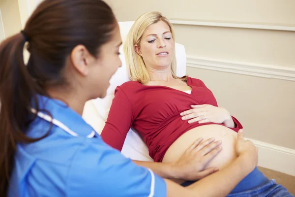 Hamile hemşire çekle — Stok fotoğraf