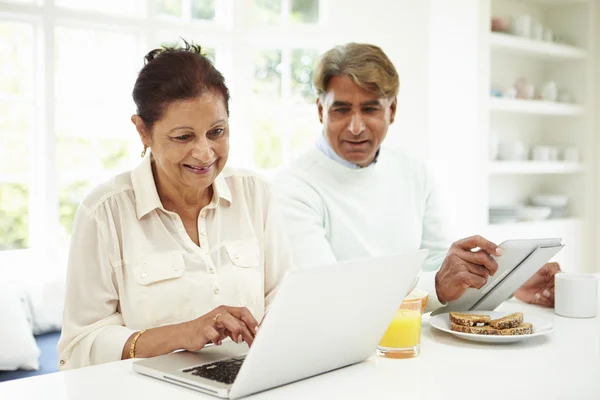 Indiska par med laptop och digital tablet — Stockfoto