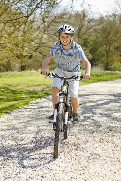 Jonge jongen rijden fiets langs land spoor — Stockfoto