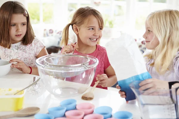 Três meninas fazendo cupcakes na cozinha — Fotografia de Stock