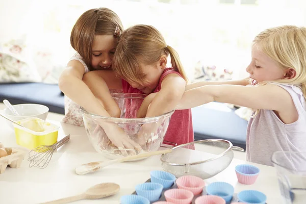 Drie meisjes maken cupcakes in keuken — Stockfoto