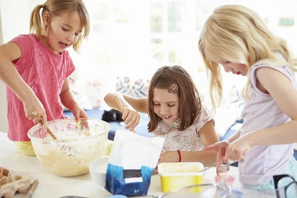 三个女孩在厨房里制作纸杯蛋糕 — 图库照片