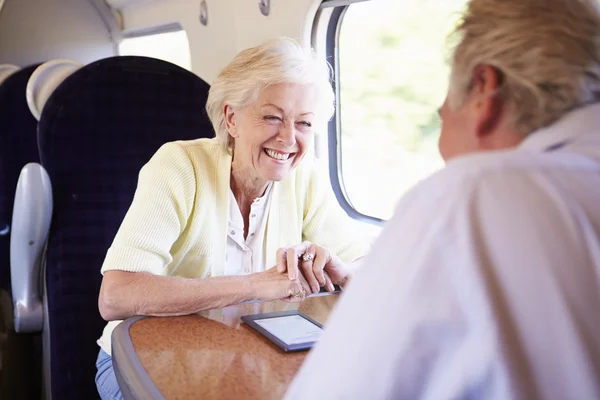 Старшая пара путешествует на поезде — стоковое фото