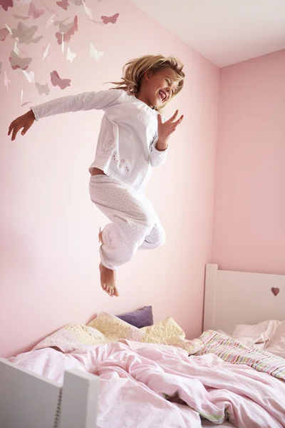 Junges Mädchen springt auf ihr Bett — Stockfoto