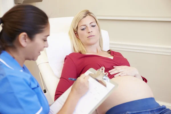 Hamile hemşire çekle — Stok fotoğraf