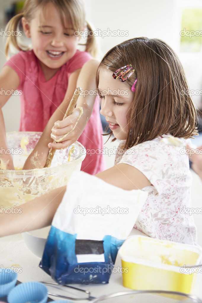 Two Girls Making Cupcakes In Kitchen Stock Photo by �monkeybusin