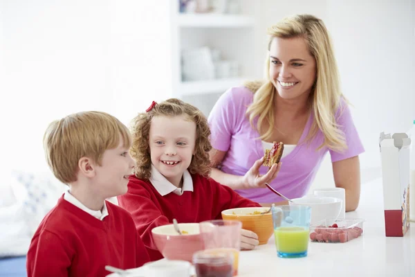 Moeder en kinderen ontbijten — Stockfoto