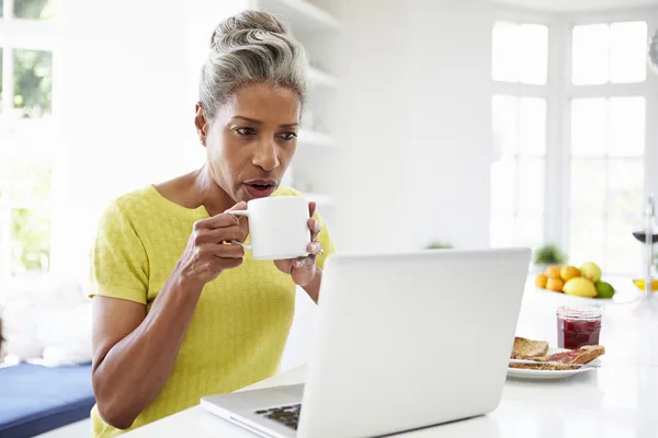 Kobieta korzystająca z laptopa w kuchni — Zdjęcie stockowe